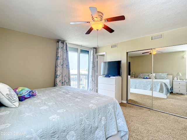 carpeted bedroom with ceiling fan, a textured ceiling, and a closet