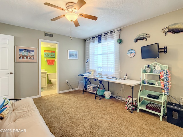 office space with a textured ceiling, carpet, and ceiling fan