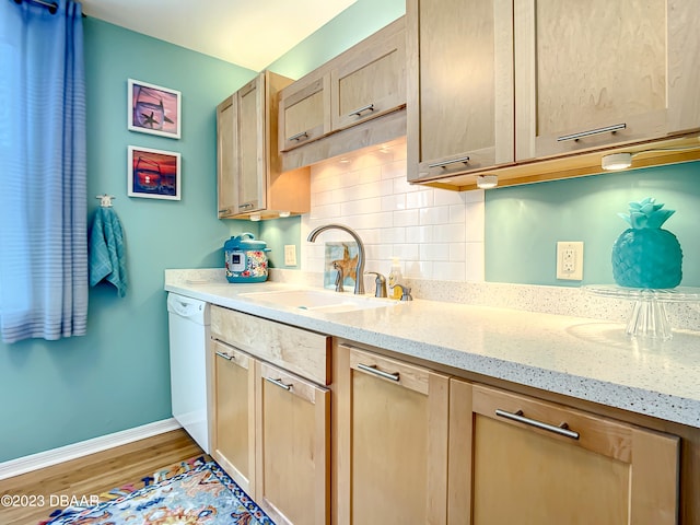 kitchen with sink, tasteful backsplash, white dishwasher, light brown cabinetry, and light wood-type flooring