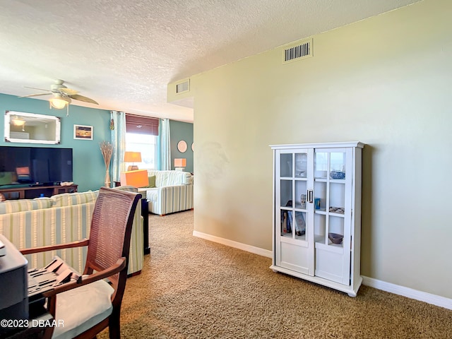 office space featuring carpet floors, a textured ceiling, and ceiling fan