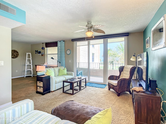 living room featuring carpet, a textured ceiling, and ceiling fan