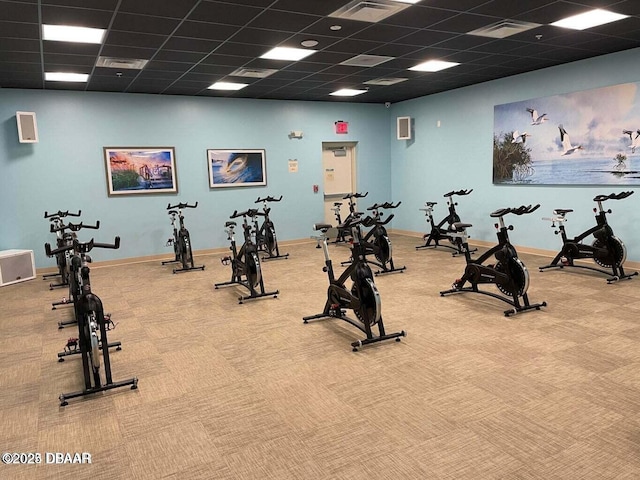 workout area featuring carpet flooring and a paneled ceiling