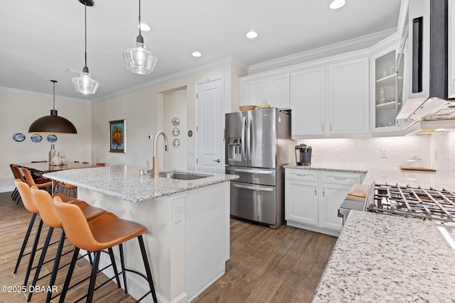 kitchen with sink, stainless steel fridge with ice dispenser, a center island with sink, pendant lighting, and white cabinets