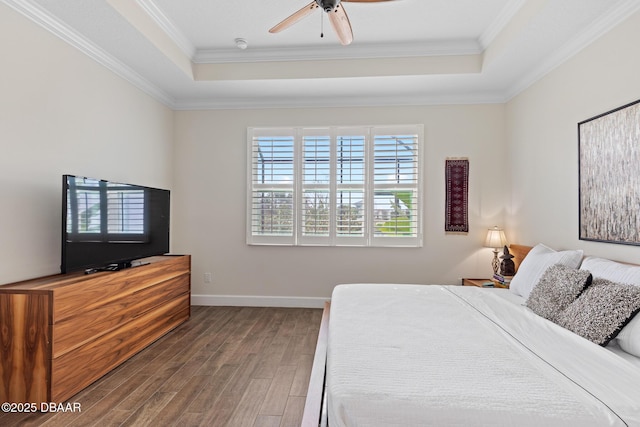 bedroom featuring dark wood-type flooring, ceiling fan, crown molding, and a raised ceiling