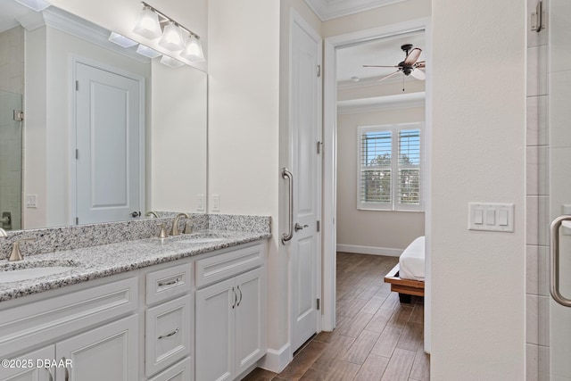 bathroom featuring ornamental molding, an enclosed shower, ceiling fan, and vanity