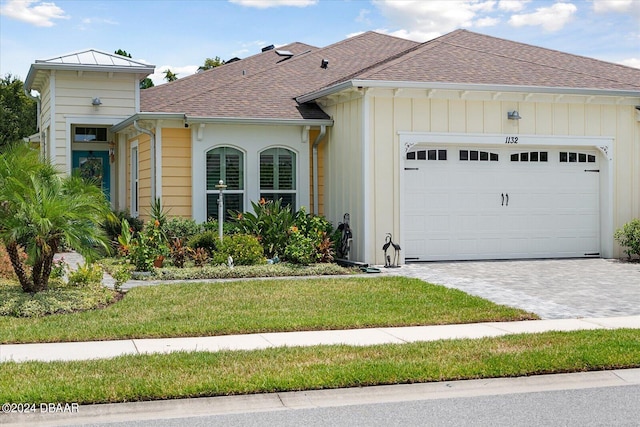 view of front of property featuring a garage and a front lawn