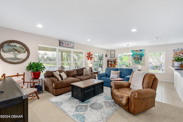 carpeted living room featuring an inviting chandelier