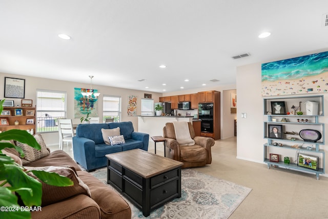 living room with light carpet and a notable chandelier