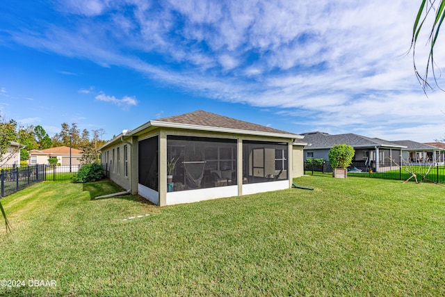 back of property with a lawn and a sunroom