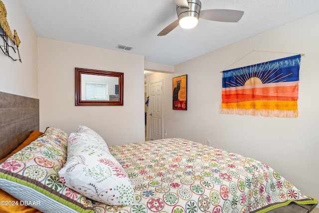 bedroom with a textured ceiling and ceiling fan