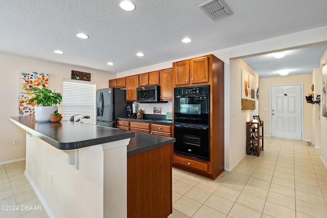 kitchen featuring a kitchen breakfast bar, black appliances, and a textured ceiling