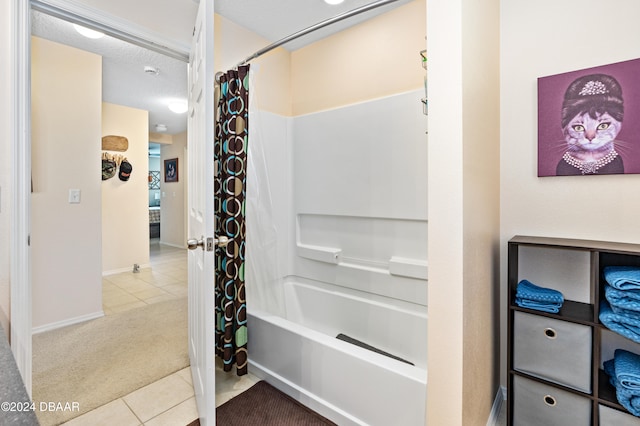 bathroom with tile patterned flooring, a textured ceiling, and shower / bath combination with curtain