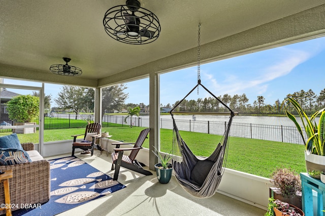 sunroom featuring a water view