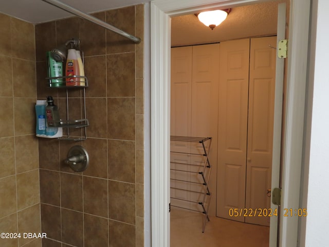 bathroom featuring a textured ceiling and tiled shower