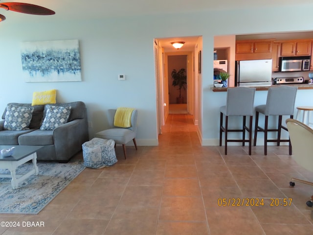 tiled living room with ceiling fan