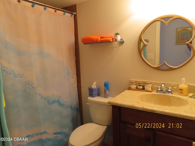 bathroom featuring toilet, vanity, and walk in shower