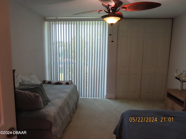 bedroom with ceiling fan, a closet, and light colored carpet