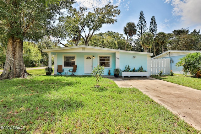 single story home featuring a front lawn