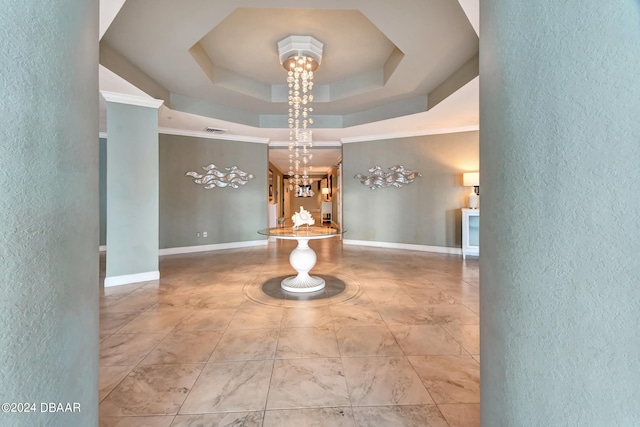 hallway featuring crown molding, a chandelier, and a raised ceiling