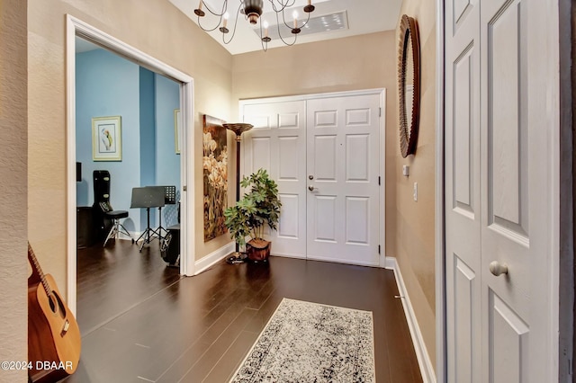 foyer with dark hardwood / wood-style floors and a chandelier