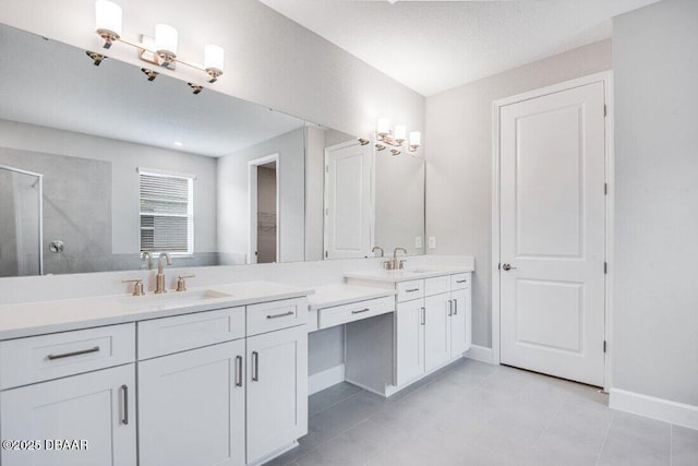 bathroom with a textured ceiling, tile patterned flooring, vanity, and an enclosed shower