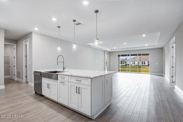 kitchen with white cabinetry, sink, dishwasher, hanging light fixtures, and a raised ceiling