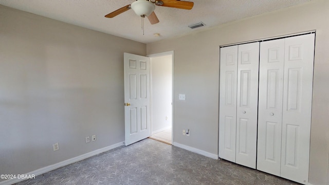 unfurnished bedroom featuring a textured ceiling, ceiling fan, and a closet