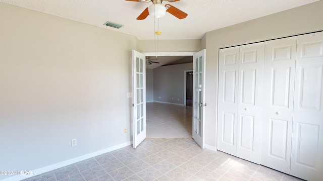 unfurnished bedroom with a textured ceiling, ceiling fan, and a closet