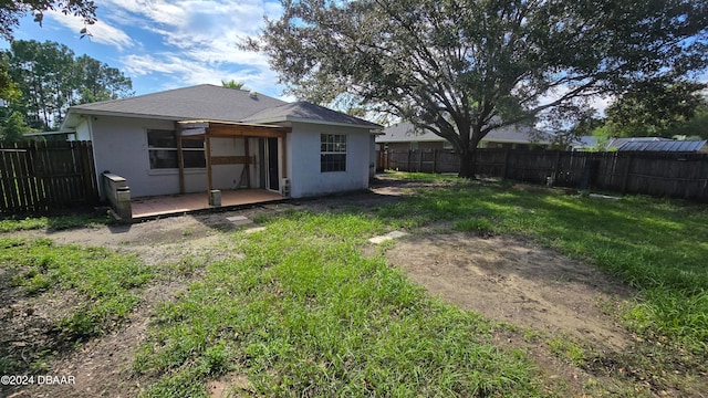 rear view of property with a lawn and a patio