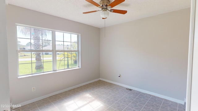 unfurnished room with a textured ceiling, light tile patterned floors, and ceiling fan