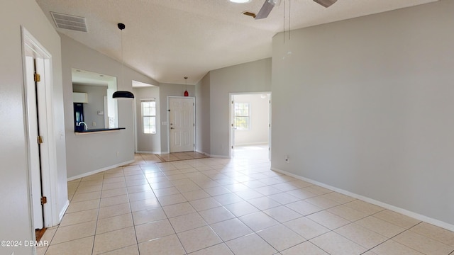 tiled entrance foyer featuring ceiling fan, a textured ceiling, and vaulted ceiling