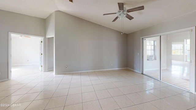 tiled spare room featuring ceiling fan, a textured ceiling, cooling unit, and lofted ceiling