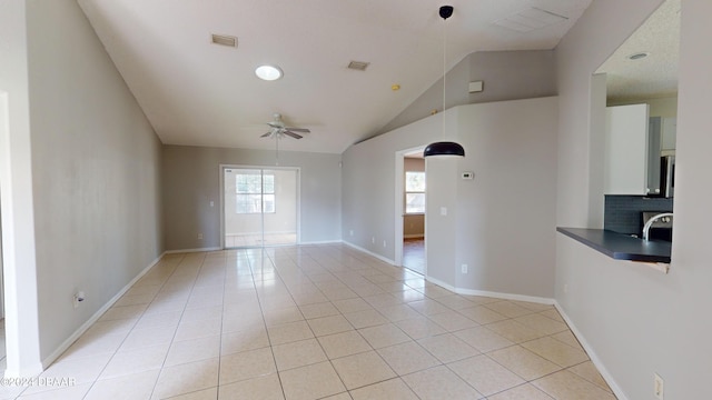 spare room featuring light tile patterned flooring, lofted ceiling, and ceiling fan