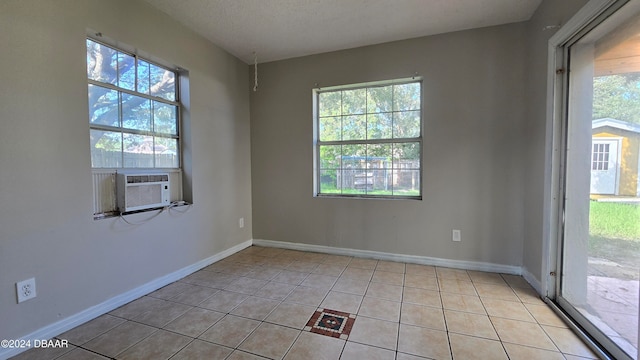 empty room featuring a textured ceiling, cooling unit, and light tile patterned floors