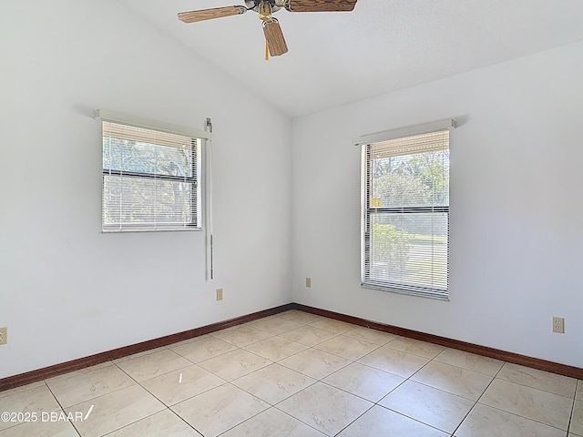 spare room featuring light tile patterned floors, baseboards, and vaulted ceiling