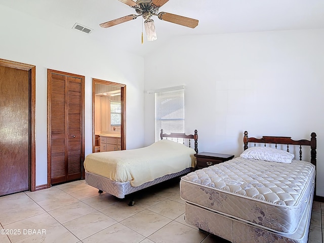 bedroom with visible vents, two closets, a ceiling fan, light tile patterned flooring, and vaulted ceiling