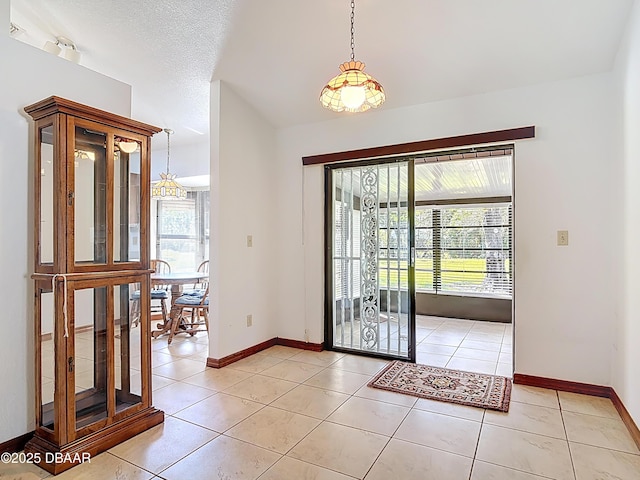 entryway with a wealth of natural light, baseboards, and light tile patterned floors