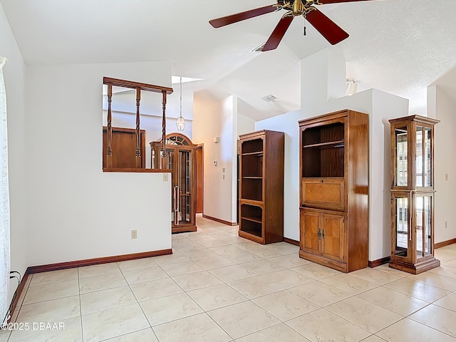 spare room featuring light tile patterned floors, a ceiling fan, baseboards, visible vents, and vaulted ceiling