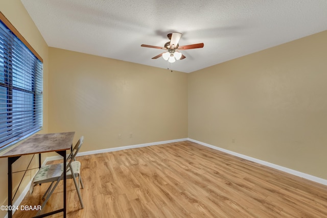 unfurnished office with a textured ceiling, light hardwood / wood-style flooring, and ceiling fan