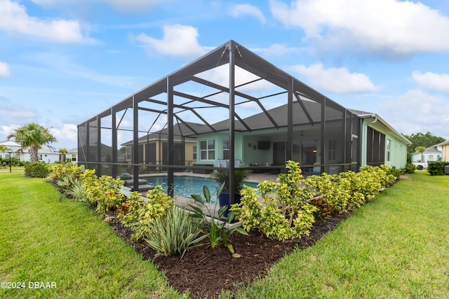 rear view of property with a lanai, a yard, and a patio area