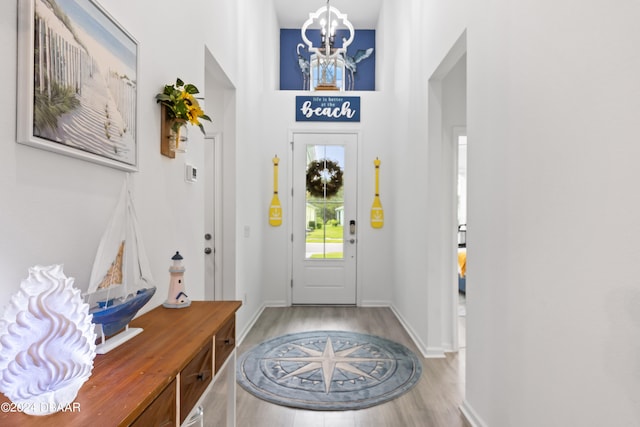 foyer with light wood-type flooring and a notable chandelier