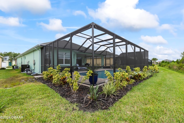 back of property featuring glass enclosure and a yard