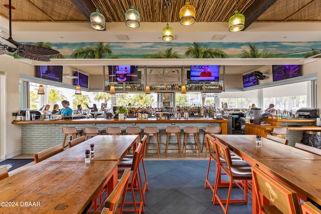 bar featuring dark tile patterned floors, a healthy amount of sunlight, and wood counters