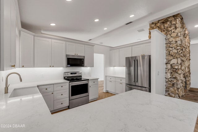 kitchen featuring white cabinetry, sink, appliances with stainless steel finishes, and tasteful backsplash