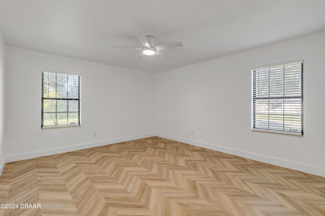 unfurnished room with ceiling fan and light parquet floors