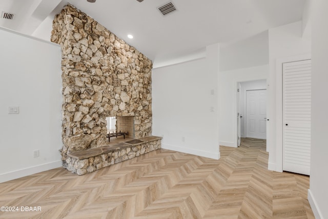 unfurnished living room featuring a fireplace, light parquet floors, and high vaulted ceiling