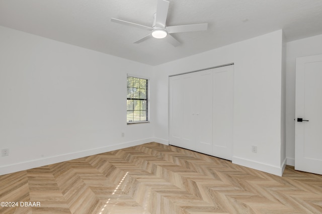 unfurnished bedroom with ceiling fan, a closet, and light parquet flooring