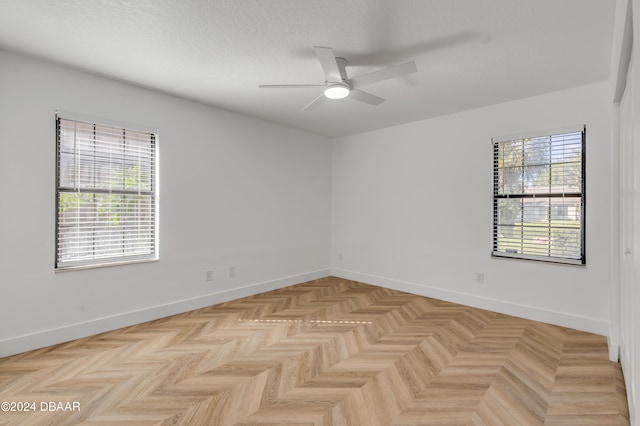 unfurnished room featuring ceiling fan, a textured ceiling, and light parquet floors