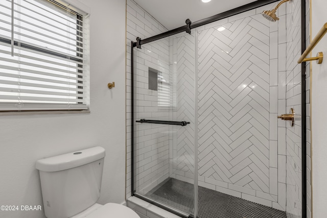 bathroom with toilet and a shower with shower door