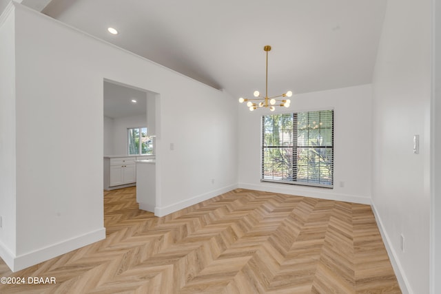 empty room featuring an inviting chandelier, light parquet flooring, and vaulted ceiling